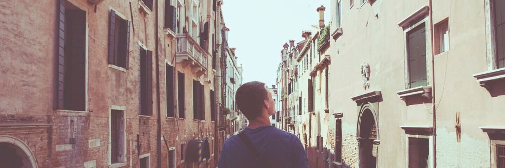 man in a city looking at a building