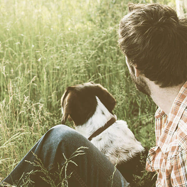 man and his dog looking into a field